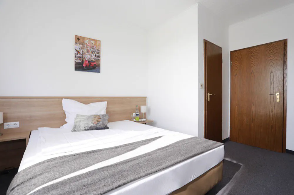Geräumiges Gästezimmer mit Doppelbett und Nachttisch